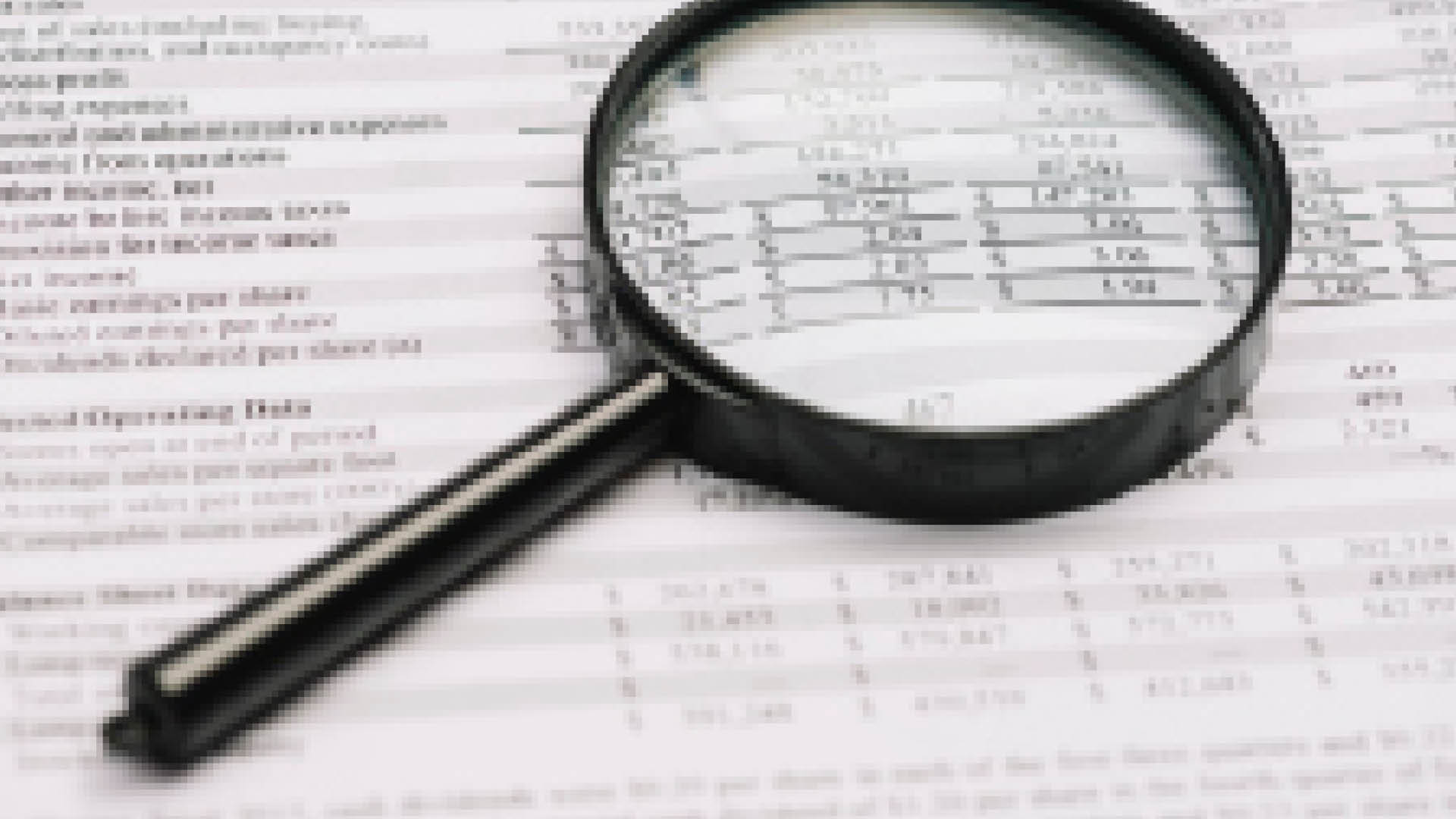 Magnifying glass on top of financial document