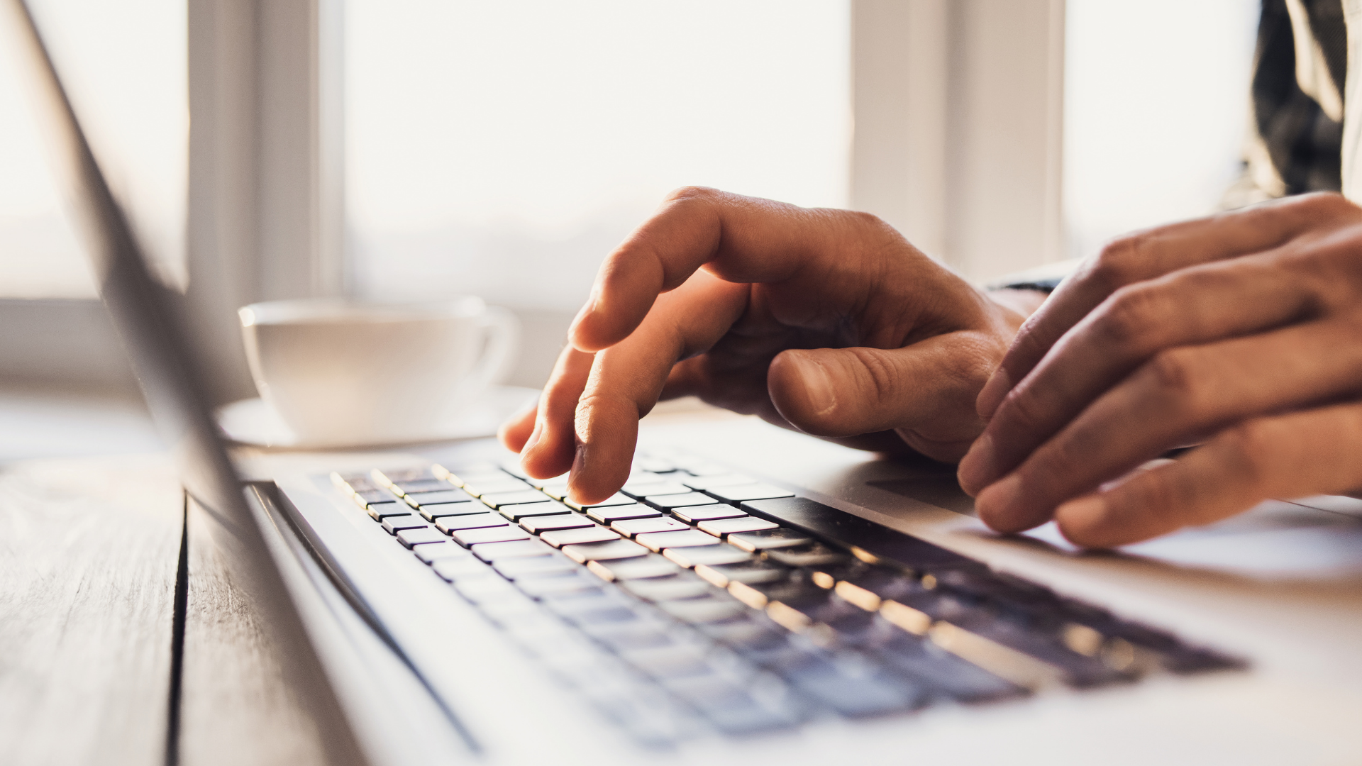 Hands typing on a laptop
