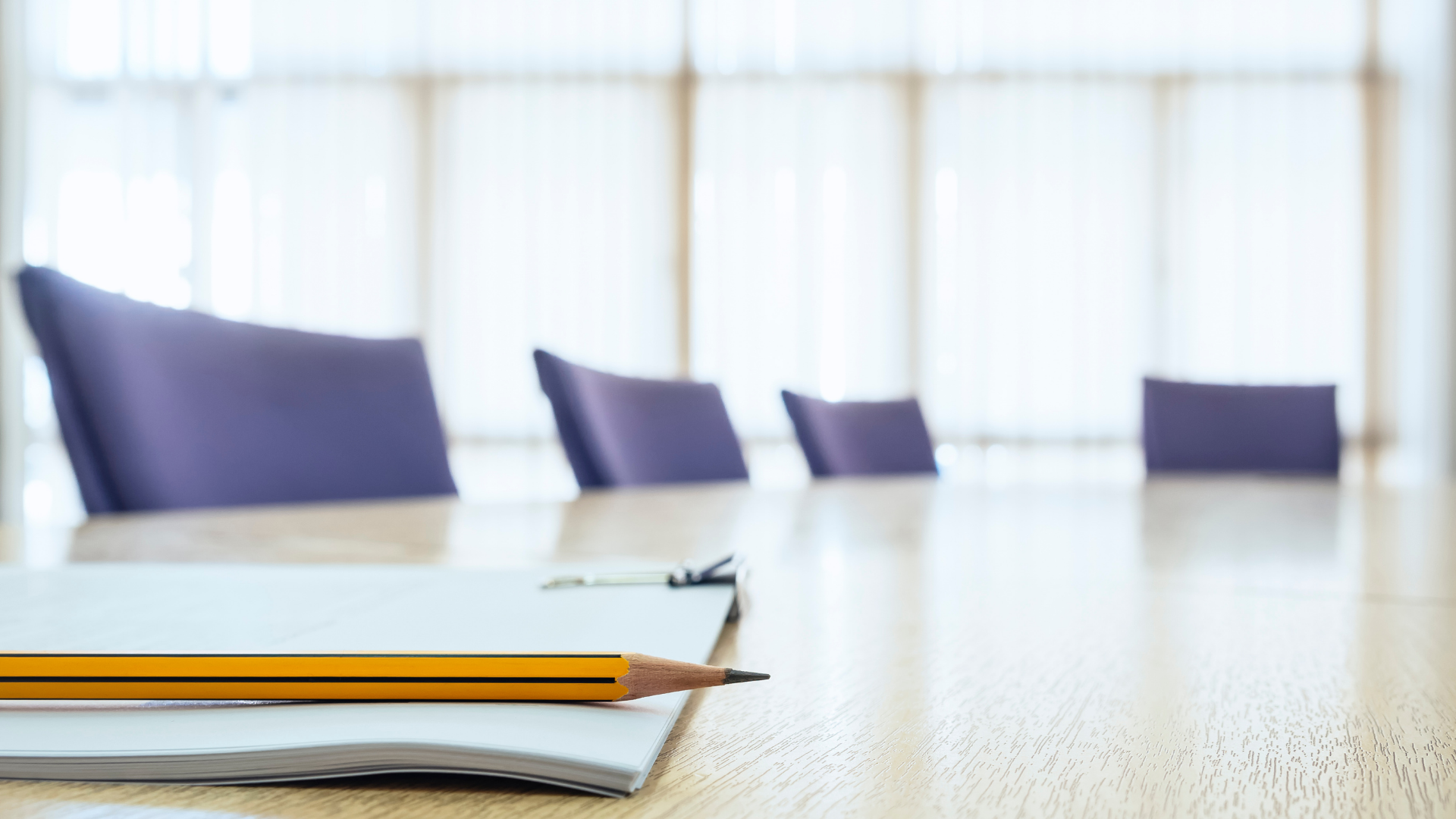 Paper and pencil sitting on a conference table
